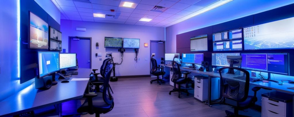 hightech-workspace-with-ergonomic-furniture-multiple-monitors-modern-lighting-min